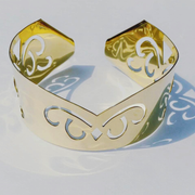 A Nzinga gold plated cuff bracelet with a floral design by Nik Spruill.