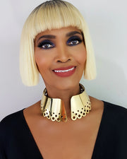 A woman with blonde hair wearing a DAHOMEY necklace and earrings by Nik Spruill.