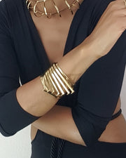 A woman wearing a Nik Spruill black top and HERU gold necklace.