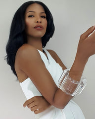 A woman in a white dress holding a Nik Spruill GLACIER phone.