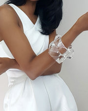 A woman in a white dress holding a Nik Spruill FREEZE cell phone.