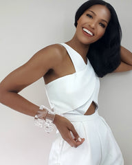 A woman in a white Nik Spruill jumpsuit posing for a picture.