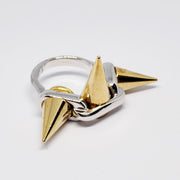 A close up of a Nik Spruill GALAXY ring with two spikes on it.