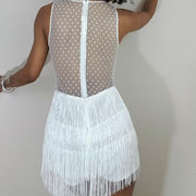 A woman wearing a Lauren fringe romper in white by Nik Spruill with polka dots.