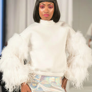 model on the runway wearing white neoprene top with feather puff sleeve facing camera