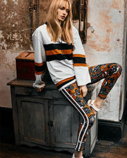 A woman wearing The Upside's FABE LACED TOP sitting on top of a wooden cabinet.