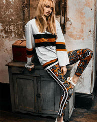 A woman wearing The Upside's FABE LACED TOP sitting on top of a wooden cabinet.
