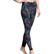 A woman in iYoga's CONSTELLATION LEGGING with a black and green pattern.