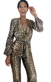 A woman wearing a Nik Spruill Savage Sheen leopard print jumpsuit.