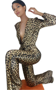 A woman in a Nik Spruill Savage Sheen leopard print jumpsuit posing for a picture.