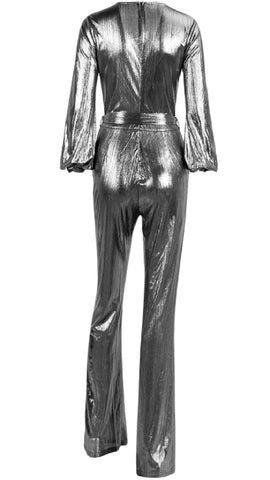 A woman is wearing a Nik Spruill DASS silver metallic jumpsuit.