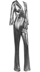 A woman wearing a Nik Spruill DASS silver metallic jumpsuit.
