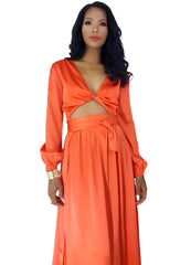 A woman wearing a Nik Spruill Effortless Double Slit Maxi Dress - Orange with a cut out back.