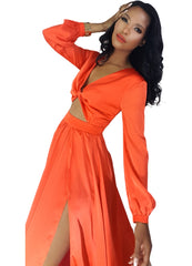 A woman in a Nik Spruill Effortless Double Slit Maxi Dress - Orange posing for a picture.