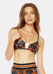 A woman in an orange and black CROP TOP by The Upside.