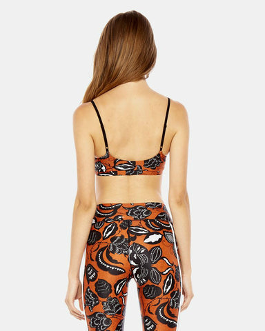 A woman wearing The Upside crop top and patterned pants.