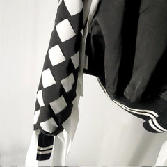 a Nik Spruill CHECKMATE FRINGE JACKET hanging on a wall.