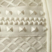 A close up of a Nik Spruill COCOON EMBRACE COAT with a bunch of rivets on it.