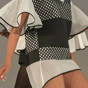 A woman is walking down the runway in a Nik Spruill CONNECTION DRESS in black and white.