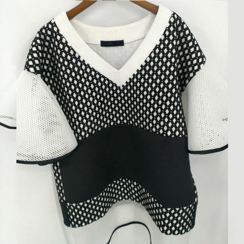 A Nik Spruill CONNECTION DRESS hanging on a wall.