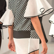 A woman walking down a runway in a Nik Spruill Connection Dress.