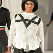 A model walks down the runway at a fashion show wearing the Crossroads Top by Nik Spruill.