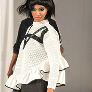 A woman walking down a runway wearing a Nik Spruill Crossroads Top and black pants.