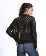 A woman wearing a Moves Athletix EFFORTLESS MOTION JACKET and leggings.