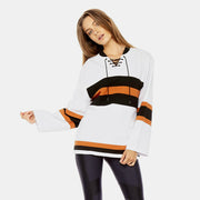 A woman in black leggings and a white FABE LACED TOP from The Upside.