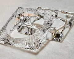 A pair of FROSTY silver rings sitting on top of a glass tray by Nik Spruill.