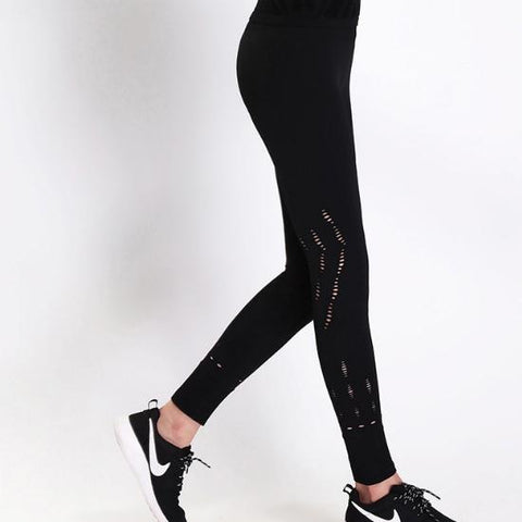 a woman wearing Nik Spruill's REBEL HIGH WAIST LEGGING BLACK and a pair of sneakers.