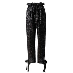 A Nik Spruill Maya relaxed fit sequined pant - black with a bow at the waist.